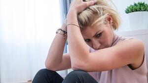 Junge Frau sitzt traurig auf dem Fussboden einer Wohnung