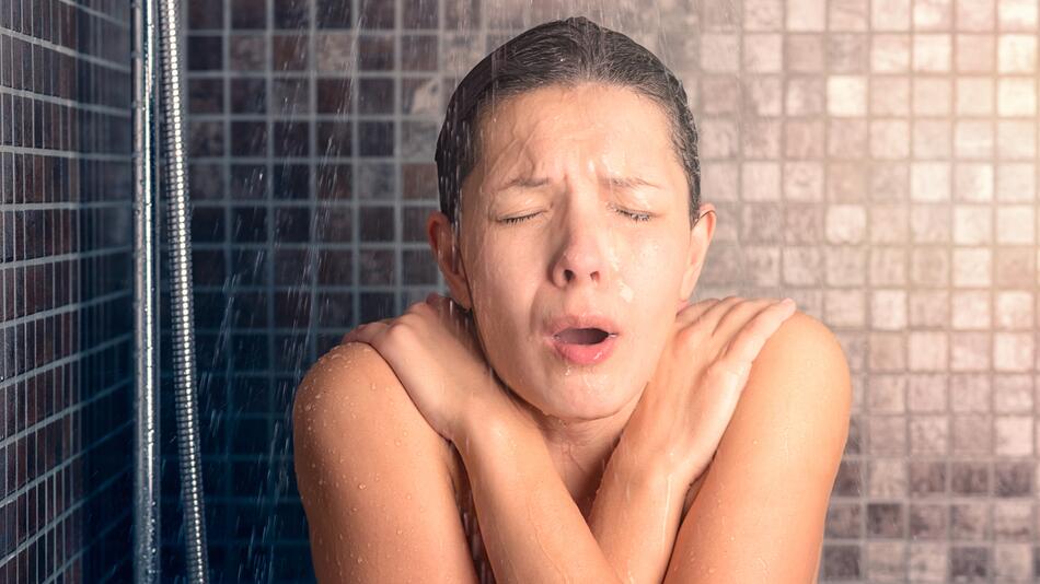 Frau ist unter der Dusche kalt