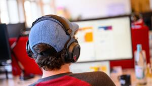 Ein Mitarbeiter mit Kopfhörern vor einem Computer-Bildschirm