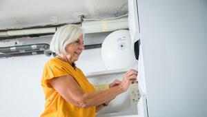 Eine Frau bedient die Zeitschaltuhr einer Heizungsanlage