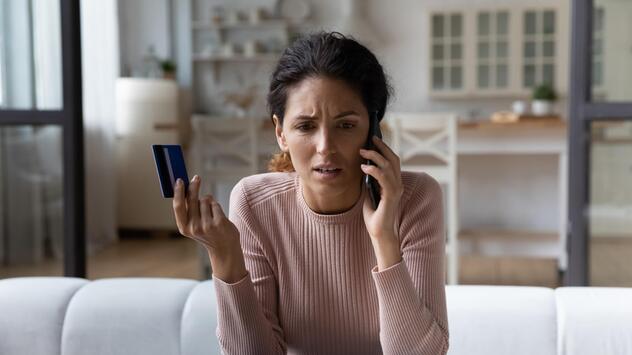 Frau geschockt am Telefon