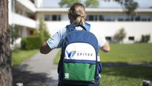 Frau trägt einen Rucksack mit der Aufschrift "Spitex"