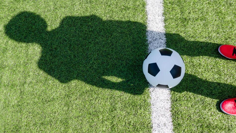 Schatten eines Kindes auf dem Fussballfeld