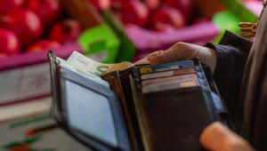 Eine Frau holt eine 5-Euro-Banknote aus ihrem Portemonnaie