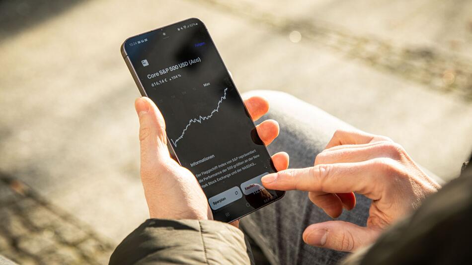 Ein Mann benutzt App für ETF-Kauf
