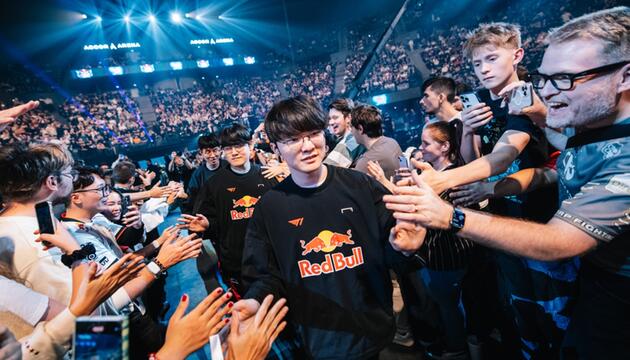 Das "League of Legends"-Team T1 läuft durch eine Menge jubelnder Menschen in einem grossen Stadion.