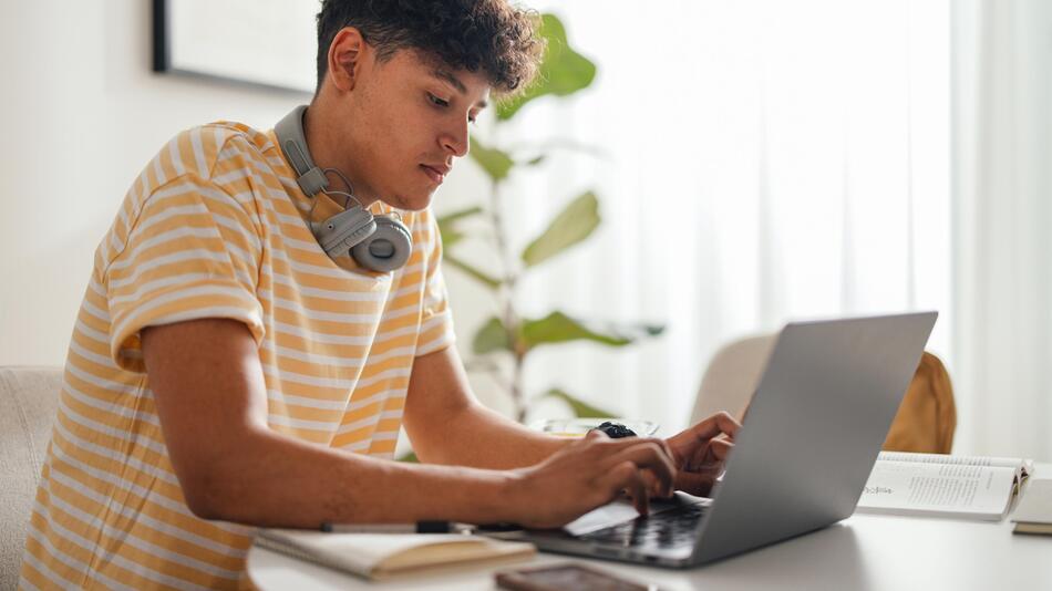 Junger Mann arbeitet am Laptop