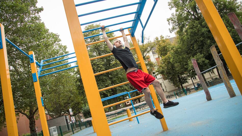 Mann treibt Sport in einem Calisthenics-Park