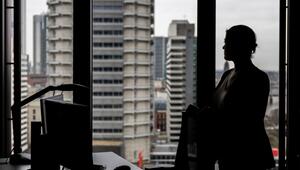 Frau steht an ihrem Arbeitsplatz am Fenster