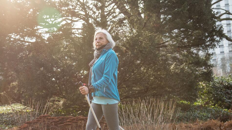 Eine Seniorin macht Nordic Walking