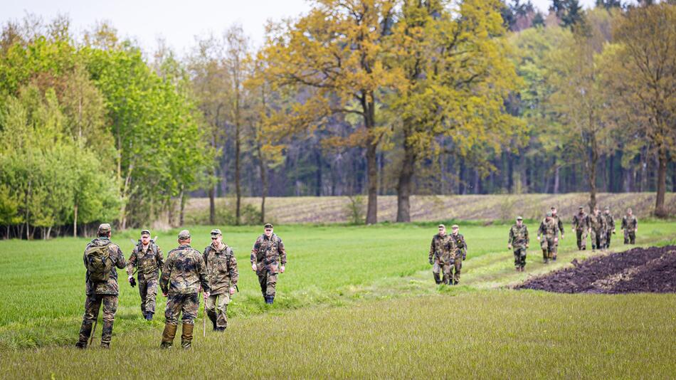 Soldaten der Bundeswehr suchen ein Feld ab.