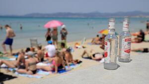 Glasflaschen stehen auf einer Mauer am Strand auf Mallorca.