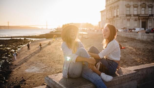 zwei lachende Frauen am Strand in Portugal