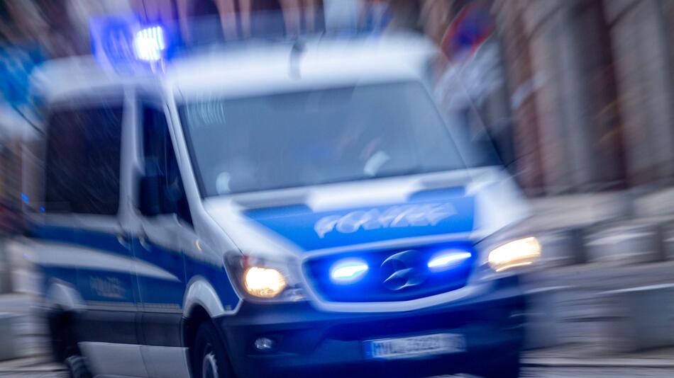 Einsatzfahrzeug der Polizei fährt mit Blaulicht durch Innenstadt