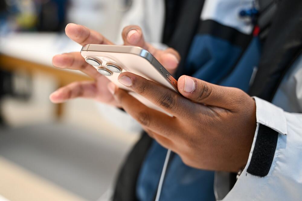 Ein Mann hält ein iPhone 16 in den Händen