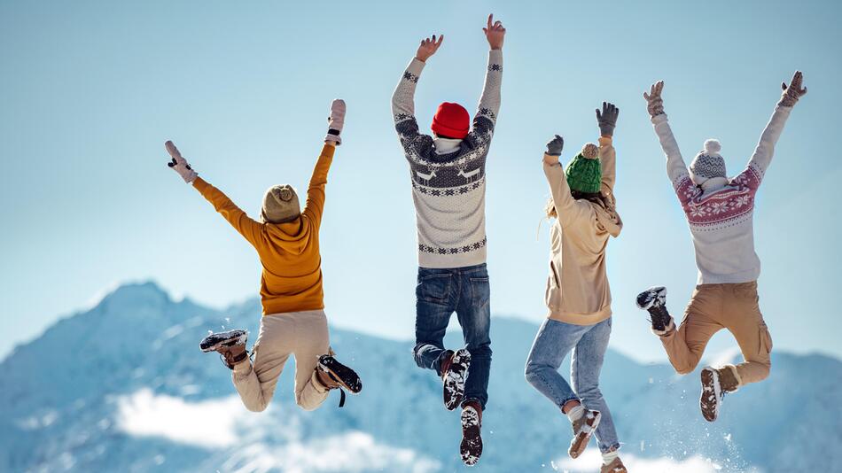 Menschen springen im Schnee.