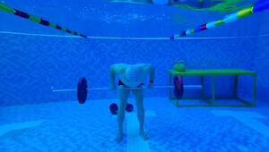 Nasse Einheit: Mann trainiert mit Langhantel im Schwimmbecken
