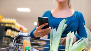 Eine Frau mit Smartphone kauft ein