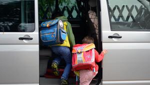 Schulkinder steigen in ein privates Fahrzeug