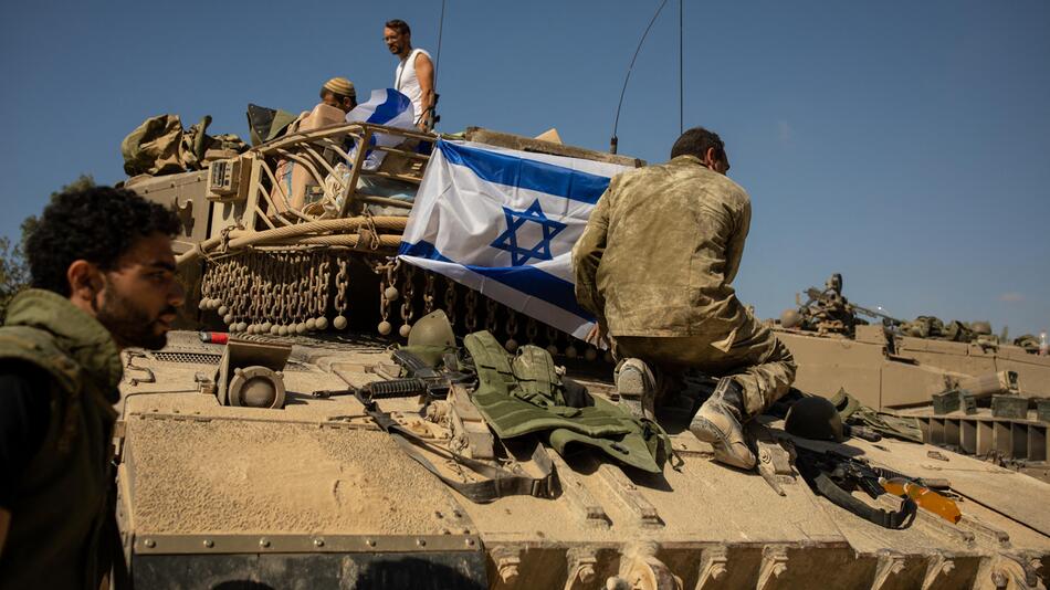 Ein Soldat befestigt die israelische Flagge an einem Panzer
