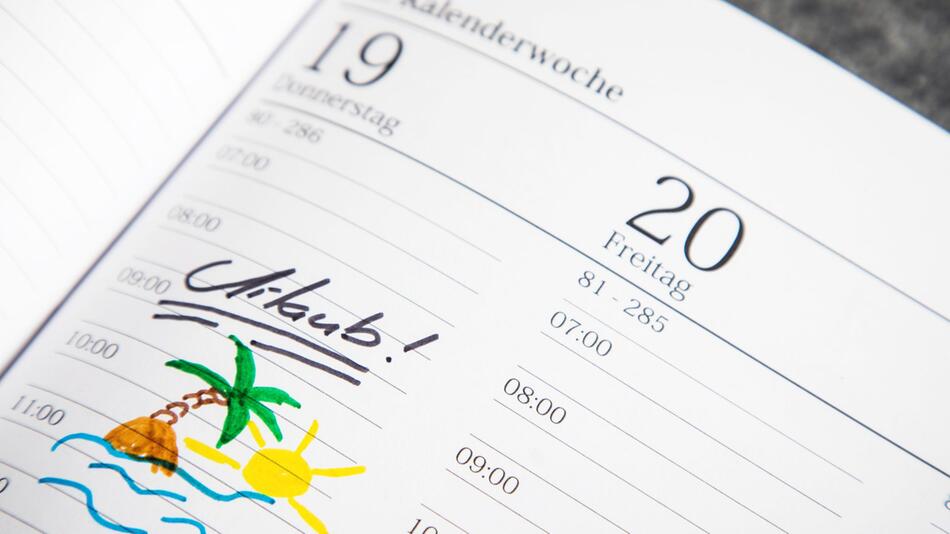 Eine Palme und das Wort Urlaub stehen in einem Planer