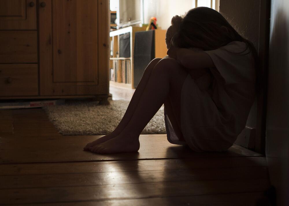 Schulkind sitzt traurig zuhause