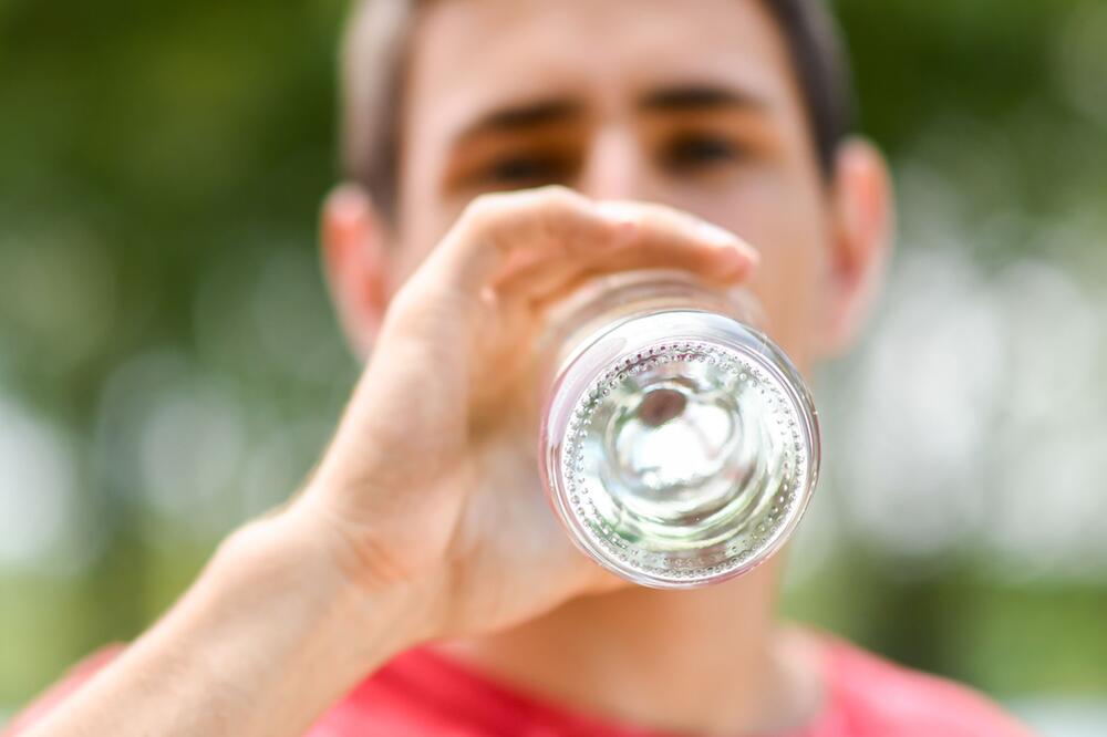 Mann trinkt aus einer Wasserflasche