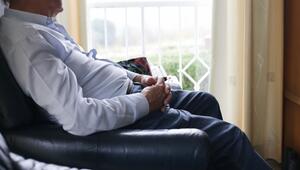 Senior sitzt zu Hause in einem Sessel