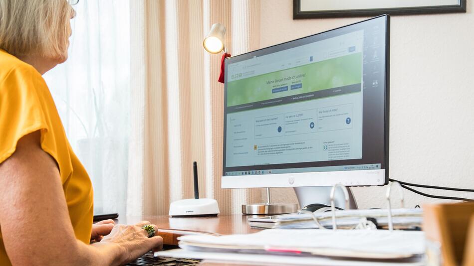 Seniorin macht eine Steuererklärung am PC