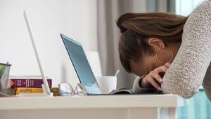 Eine junge Frau legt den Kopf auf den Tisch