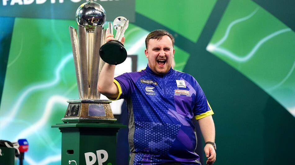 Luke Littler jubelt mit dem Pokal für den zweiten Platz bei der Darts-WM.