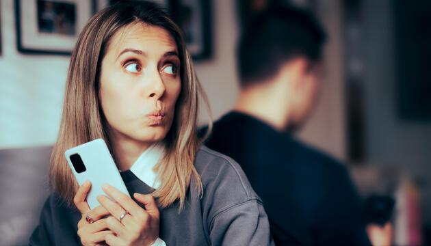 Ertappt schauende Frau mit dem Rücken zu einem Mann