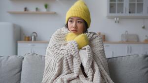 Frau sitzt in Decke auf der Couch 