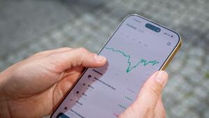 Eine Frau nutzt eine Handy-App, um ihr Finanz-Portfolio anzusehen