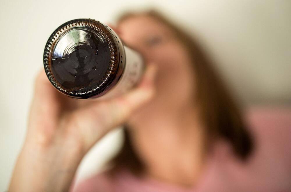 Frau trinkt aus Bierflasche