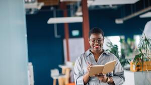 Eine junge Frau schreibt in ein Notizheft