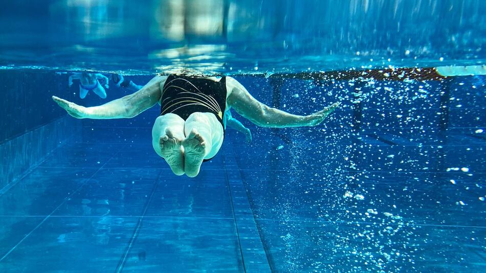 Seniorin schwimmt in einem Freibad