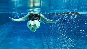 Seniorin schwimmt in einem Freibad