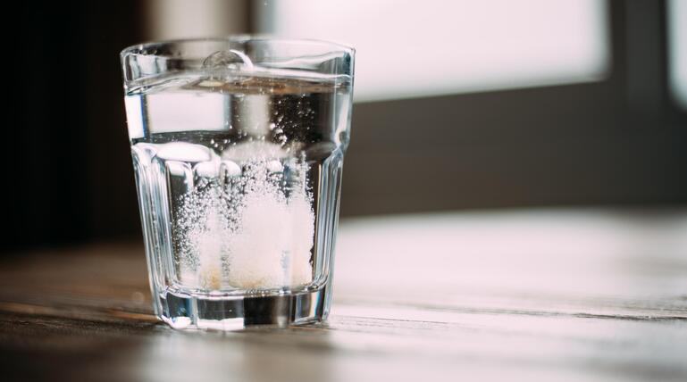 Brausetablette löst sich in Wasserglas auf