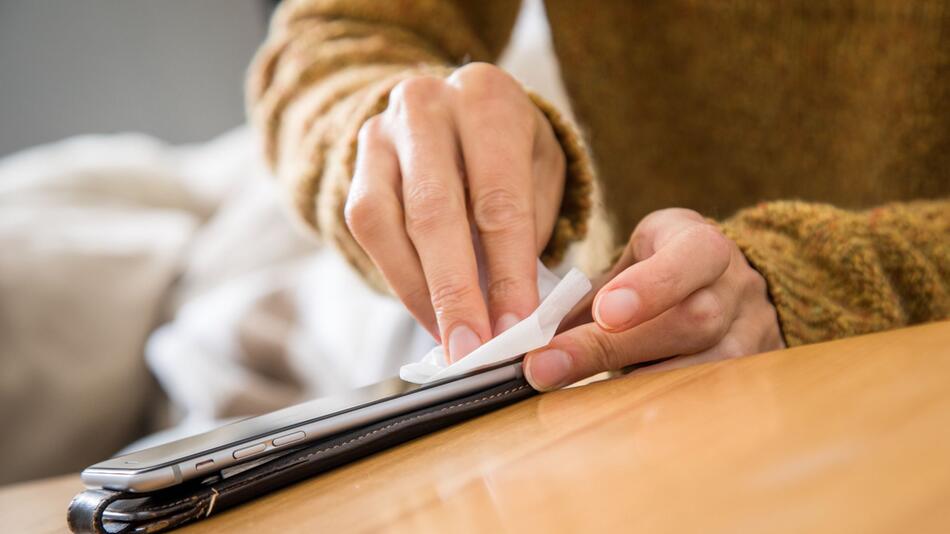 Ein Smartphone wird mit einem Tuch gereinigt