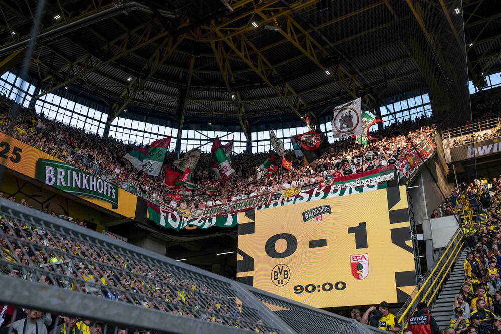 Die Augsburger Fans im Dortmunder Westfalenstadion jubeln über der Anzeigetafel.