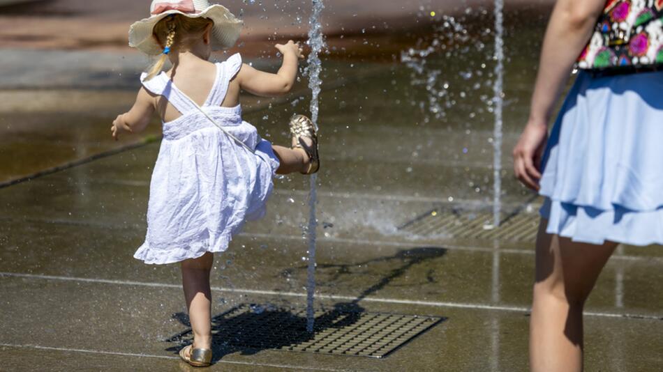Symbolbild: Mädchen und Frau im Sommer an einem Brunnen