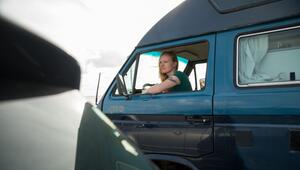 Eine Frau blickt aus dem fenster eines Campervans