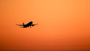 Ein Flugzeug hebt vor orangefarbenem Himmel ab