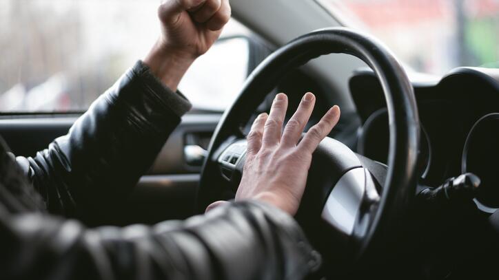 Mann im Auto ärgert sich am Steuer