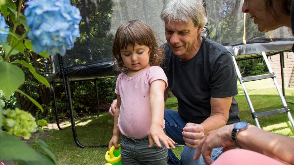 Grosseltern spielen mit ihrer Enkelin im Garten
