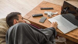 Ein Mann mit Erkltung bedient ein Laptop