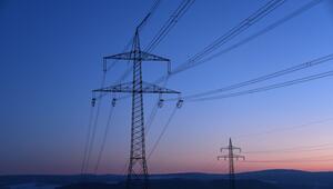 Strommasten in der Morgendämmerung auf einem Feld