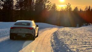 Auto fährt bei tiefstehender Sonne über eine verschneite Strasse