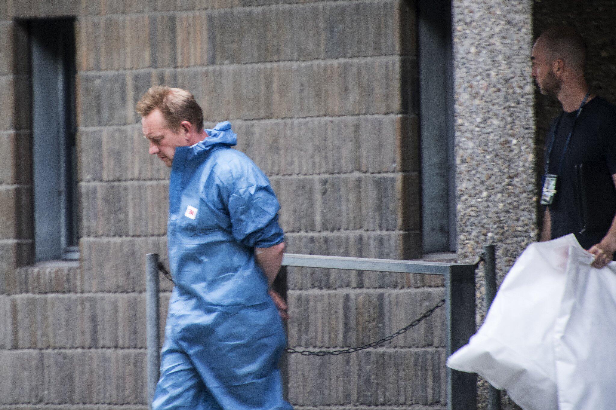  Peter Madsen, a Danish inventor and engineer, is escorted in a blue jumpsuit by police into a courthouse for his trial for the murder and dismemberment of Swedish journalist Kim Wall in August 2017.